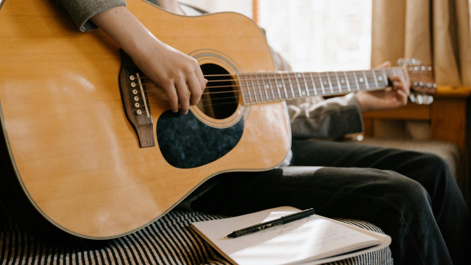 Person With Guitar Composing A Song Scaled Aspect Ratio 1600 900